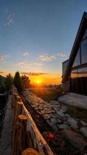 a sunset over a stone path next to a house at paradise valley bungalow in Ardeşen