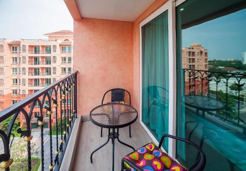 a balcony with a chair and a suitcase at 7Seas in Jomtien Beach