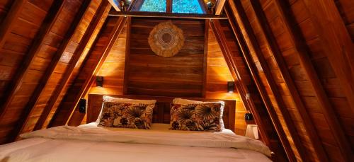 a bed in a room with a wooden wall at D'Cabin Villa Uluwatu in Uluwatu