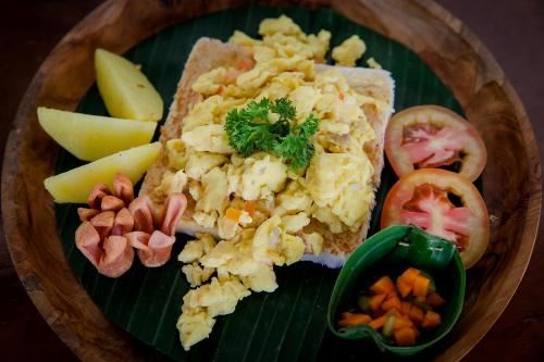 Un plato de comida con huevos, pan, fruta y nueces. en Sandat Bali Ubud, en Ubud
