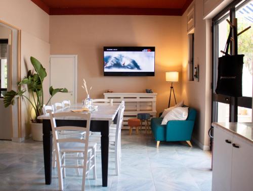 a dining room with a table and a tv on the wall at Villa Panoramica Sunset House in Torre Vado