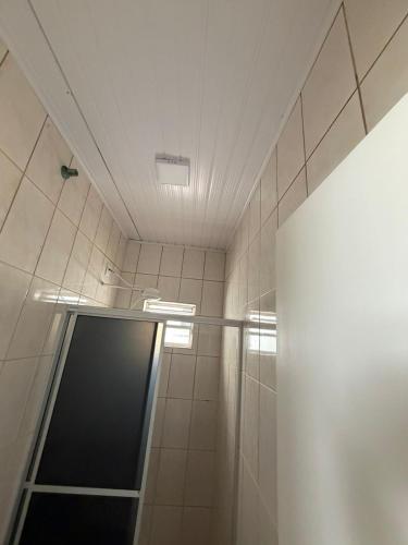 a shower with a glass door in a bathroom at Apart Centro 06 in Tubarão