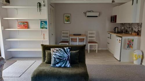 a living room with a couch and a kitchen at Amblers Rest Accomodation in Drury