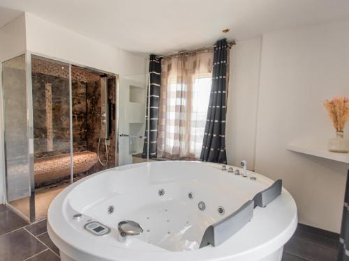 a large white tub in a bathroom with a shower at Belle vue in Flayosc