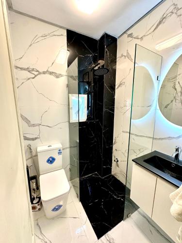 a bathroom with a toilet and a shower at Palm & Tide Kenitra Residence in Kenitra