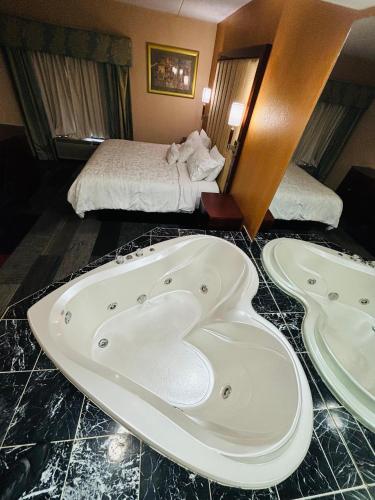a hotel room with a bath tub and a bed at Hotel M Mount Pocono in Mount Pocono