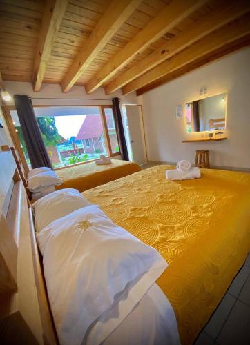 a bedroom with a large bed with a large window at Hotel Ensueño del Bosque Valle de Bravo in Valle de Bravo
