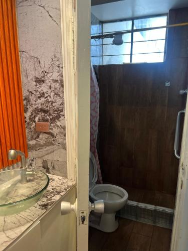 a bathroom with a toilet and a sink at Suite Acogedora Centro de Tulcán in Tulcán