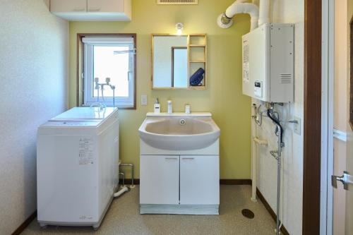 a bathroom with a sink and a mirror at Furano Lavender House helps guests book great restaurants in Furano in Furano