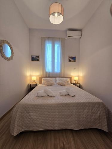 a bedroom with a large bed with two towels on it at Stone House with Panoramic Views in Marmaro in Mármaron