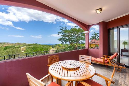 a room with a table and chairs on a balcony at Recently Renovated Luxury Condo with Resort-Style Beach Club Access and Ocean Views in Playa Conchal