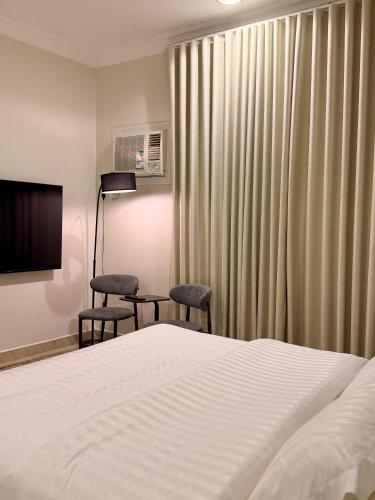a hotel room with a bed and two chairs at وسط المدينة للشقق السكنيه in Medina
