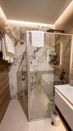 a bathroom with a shower with a glass door at Hotel Biser in Kališta