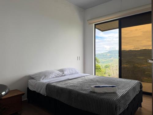 a bedroom with a bed and a large window at Altavista Cabin Rest House in Barbosa