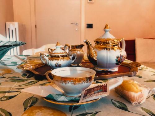 a table with a tea set and tea cups on it at Bed and Break fast JIREH in Casalecchio di Reno