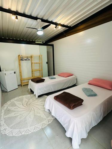 two beds sitting in a room with a rug at Sítio Vivendas in Itaipava