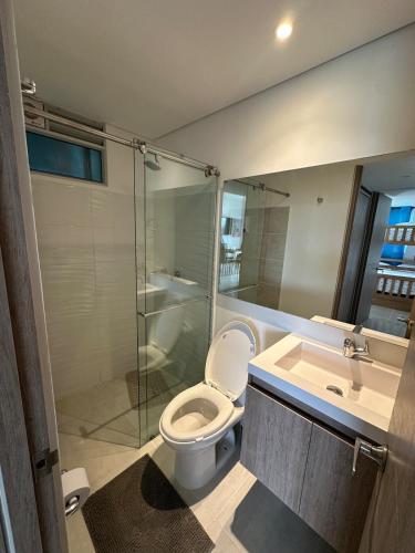 a bathroom with a toilet and a shower and a sink at Loft Apartment - Full AC With Free Parking Pool in Cartagena de Indias