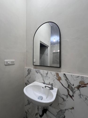 a bathroom with a sink and a mirror at Homestay Whale Shark in Pohe