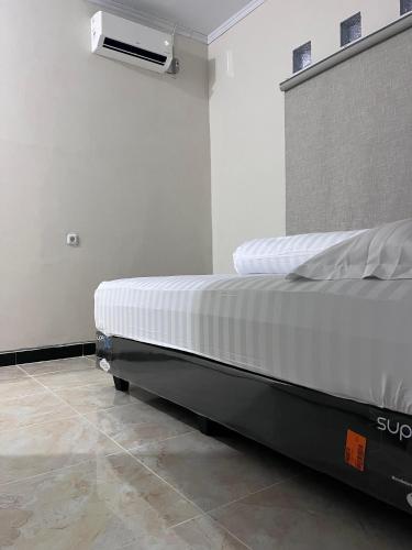 a bed in a room with a air conditioner at Homestay Whale Shark in Pohe