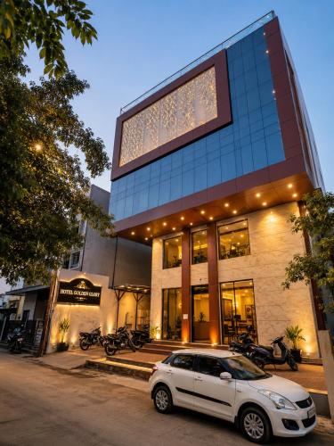 a white car parked in front of a building at Hotel Golden Glory Scheme 103 in Indore