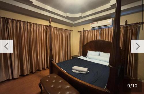 a bedroom with a canopy bed with two towels on it at Aonang Poonsiri Cozy Villa in Ban Khlong Haeng