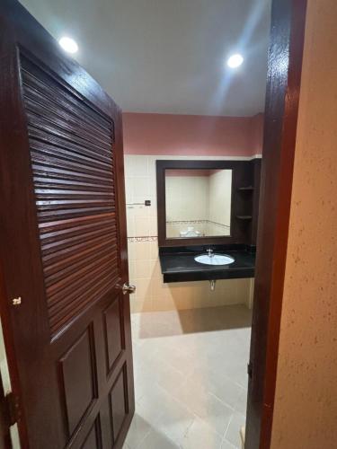 a bathroom with a sink and a mirror and a door at Aonang Poonsiri Cozy Villa in Ban Khlong Haeng