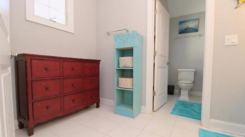 a bathroom with a red dresser and a toilet at West Cape Oasis in West Cape May