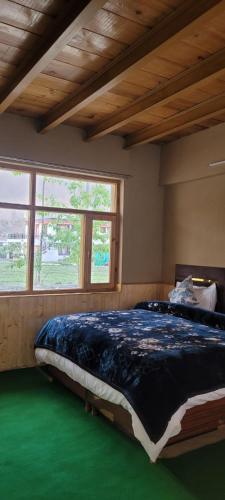 a large bed in a room with a green floor at Ochre Spiti in Lara
