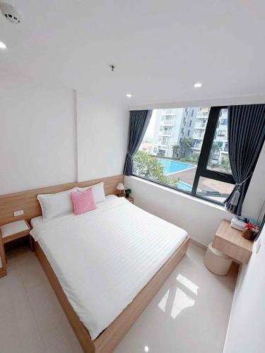 a small bedroom with a bed and a large window at Hiền Apartment in Thôn Văn Dương