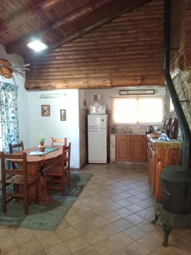 a kitchen with a table and a white refrigerator at Cabañas La Brama in Aluminé