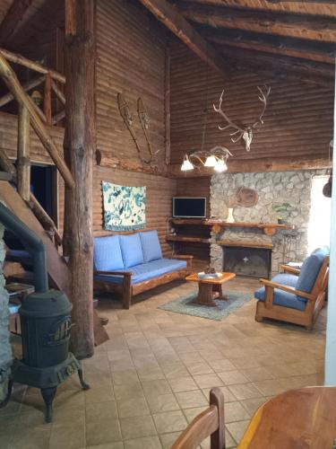 a living room with a blue couch and a fireplace at Cabañas La Brama in Aluminé