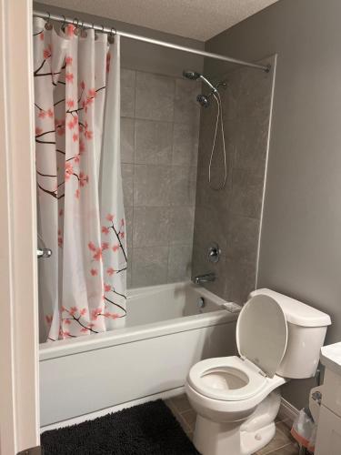 a bathroom with a toilet and a shower curtain at Cozy private basement suite with separate entrance in Calgary