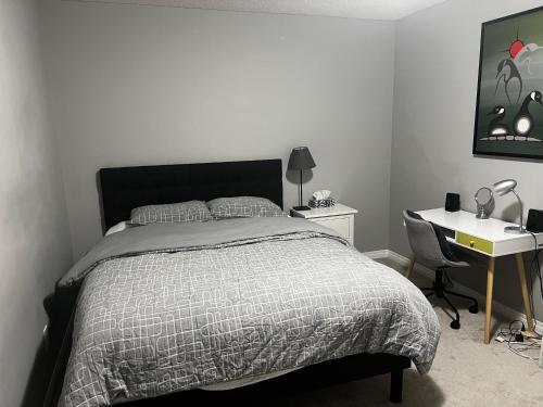 a bedroom with a bed and a desk and a bed sidx sidx sidx at Cozy private basement suite with separate entrance in Calgary