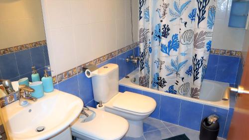 a blue and white bathroom with a toilet and a sink at Helena Seaview & Beach-apartment in Montgat