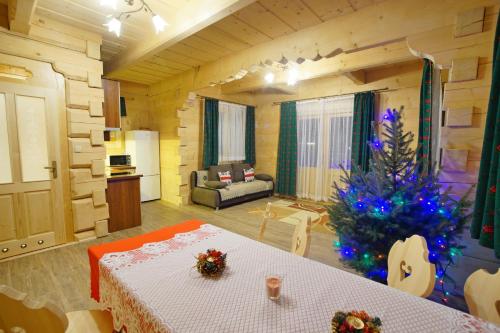 a living room with a christmas tree in a room at Domek Anielci in Zakopane