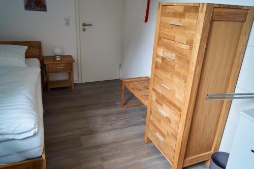 a bedroom with a wooden cabinet next to a bed at Bredeneeker Gasthaus in Rastorf