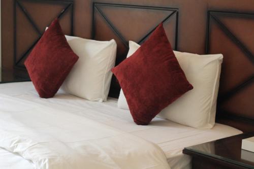 two red pillows sitting on top of a bed at APARTMENT near GULF DELMON in Dammam
