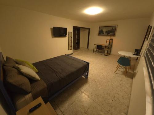 a bedroom with a bed and a living room with a table at Habitación en renta in Saltillo