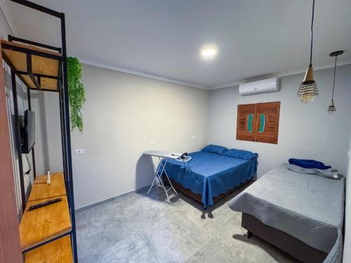a bedroom with a bed and a desk in it at Rancho de férias in Japaratinga