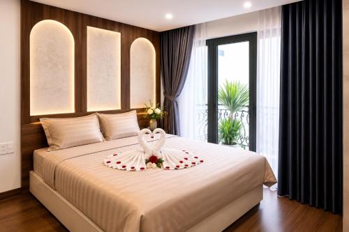 a bedroom with a bed with a swan on it at Marly Apartment in Danang