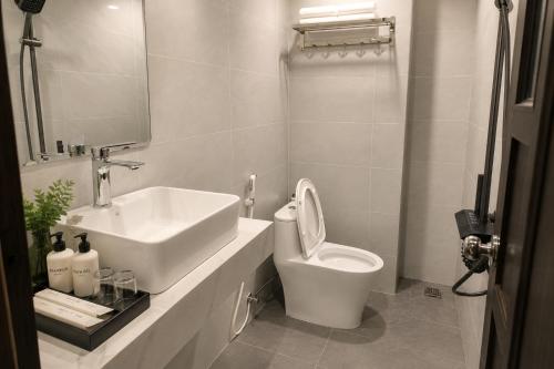 a white bathroom with a sink and a toilet at Marly Apartment in Danang