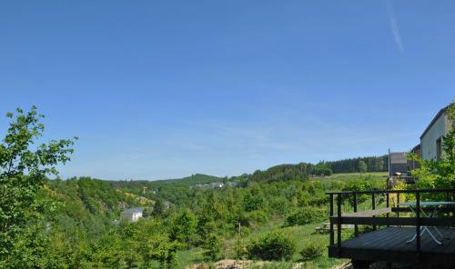 a view of a valley with trees and a building at Jardins de l'Ourthe 22 in Houffalize