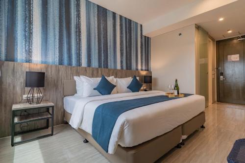 a bedroom with a large bed with blue and white pillows at Bayfront Hotel Cebu Capitol Site in Cebu City