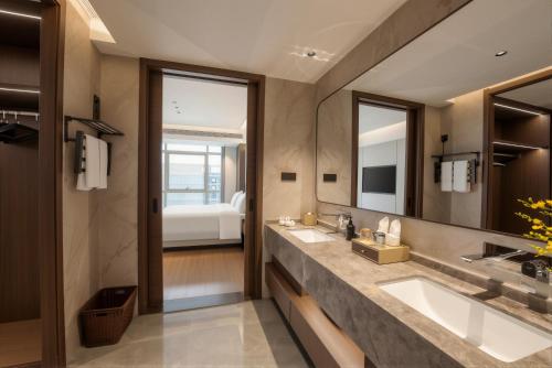 a bathroom with two sinks and a large mirror at 义乌雅寓酒店国际商贸城六区店 in Yiwu
