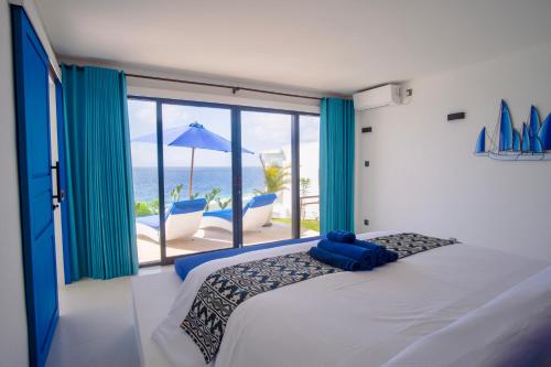 a bedroom with a bed and a view of the ocean at NEW! 2BR Ocean View, Infinity Pool, Villa Kerylos in Sampalan