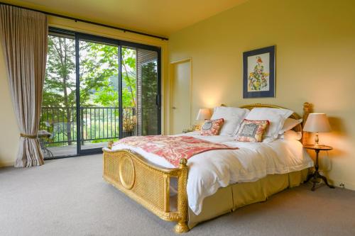 a bedroom with a bed and a large window at Ballymoney Cnoc in Tai Tapu