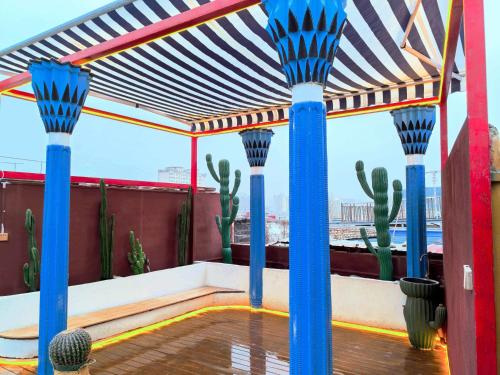 a pergola with cactuses and blue poles on a roof at Xinjiang Rhythm Hotel-疆韵民宿 in Kashgar