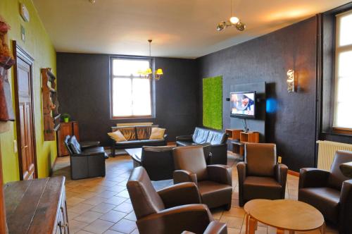 a waiting room with chairs and a couch and a tv at La Recreation in Somme-Leuze