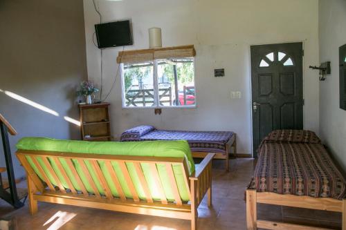 a living room with two benches and a door at El Solar in Vuelta de Obligado