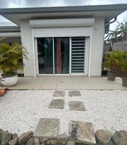 a house with a stone pathway in front of it at Appartement Butterfly in Ducos